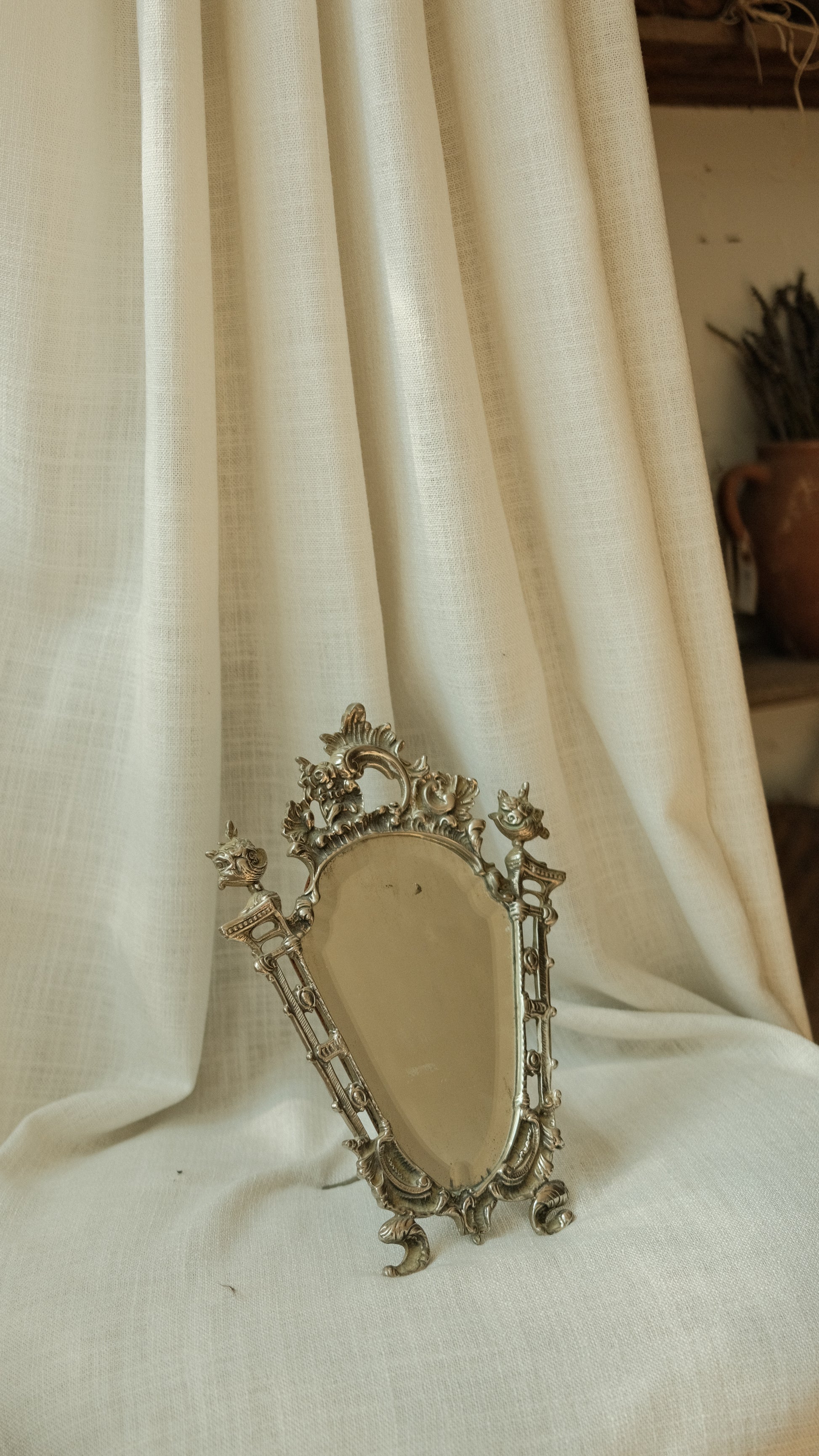 Decorative silver brooch on a white fabric background