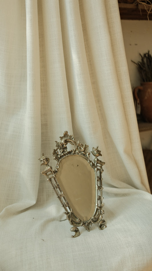 Decorative silver brooch on a white fabric background